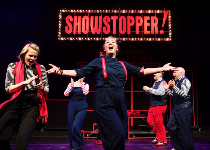 People singing on stage in a musical